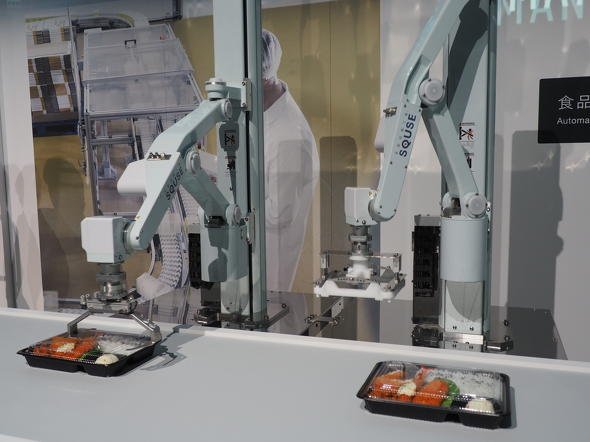 スキューズ製の2台のロボットアームがお弁当の容器に蓋をする動きの様子を披露