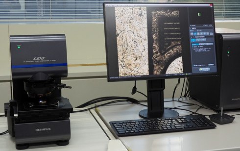 3D測定レーザー顕微鏡「LEXT OLS5000」。さまざまな産業領域における品質検査や不具合調査などに用いられる。500円硬貨を観察するデモの様子。高精度3Dデータの生成や、対象物全体のどの部分を観察しているのか一目で分かる「リアルタイム・マクロマップ」を新たに搭載し、使い勝手が向上している